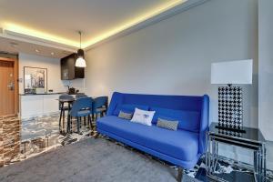 a blue couch in a living room with a kitchen at Comfort Apartments Deo Plaza in Gdańsk