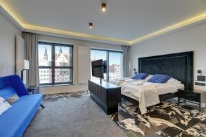 a bedroom with a large bed and a blue couch at Comfort Apartments Deo Plaza in Gdańsk