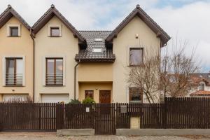 a house with a fence in front of it at Spacious Two-Story 4-Bedroom House with Parking and Garden in Warsaw by Renters in Warsaw