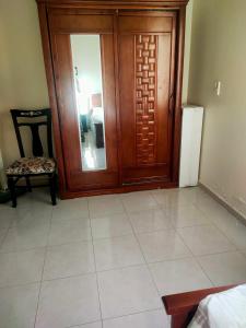 a room with a wooden door and a chair at Private Room with private bathroom in a cozy Apt. And shared area in Cairo