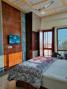 sypialnia z łóżkiem i telewizorem na ścianie w obiekcie Laxmi Jawahar Homestay w mieście Dehradun
