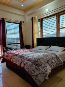 1 cama grande en un dormitorio con ventanas en Laxmi Jawahar Homestay, en Dehradun
