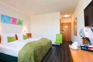 um quarto de hotel com uma cama e uma televisão de ecrã plano em Hotel Bochum Wattenscheid affiliated by Meliá em Bochum