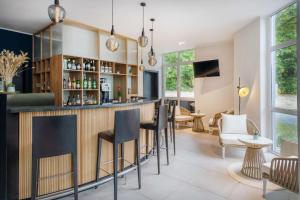 - un bar dans une salle avec des chaises et des tables dans l'établissement Hotel Bochum Wattenscheid affiliated by Meliá, à Bochum