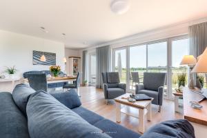 ein Wohnzimmer mit einem blauen Sofa und einem Tisch in der Unterkunft Ferienhaus Nis Randers in Olpenitz