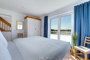 a bedroom with a bed and a large window at Ferienhaus Nis Randers in Olpenitz