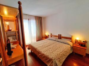 una camera con letto, scrivania e specchio di Il Fraitevino hotel bed & breakfast a Sestriere