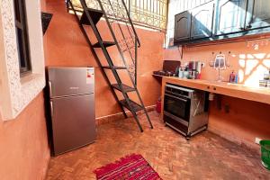 a kitchen with a metal refrigerator and a ladder at Dar Ben Saleh in Marrakesh