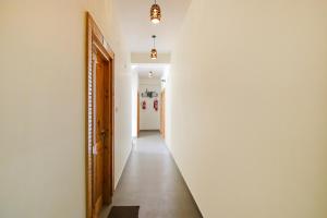 a hallway with a white wall and a door at FabHotel Himalayan Park in Bajaura
