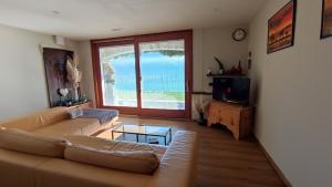 sala de estar con sofá y vistas al océano en Villa VaLuRi vista magnifica sul Lago di Como Appartamento piano terra, en Vercana