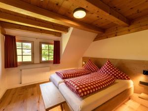 Un dormitorio con una cama con almohadas rojas. en Holzhof en Breitnau