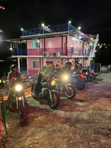un grupo de personas en motocicletas estacionado frente a un edificio en Charmtalamok Khaokho Resort, en Ban Khao Ya Nua