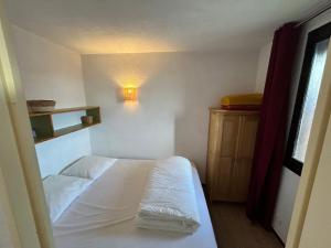 een kleine slaapkamer met een wit bed en een licht bij Boost Your Immo Le Relais Réallon 672 in Réallon