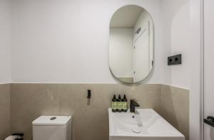a bathroom with a white sink and a mirror at Asequible apartamento a pasos de Callao in Madrid