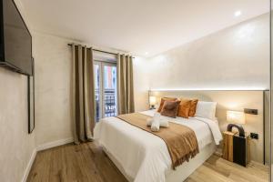 a bedroom with a large bed and a tv at Asequible apartamento a pasos de Callao in Madrid