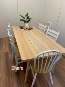 uma mesa e cadeiras de madeira com um vaso de plantas em Chapel street south yarra 阳光大房204房 em Melbourne