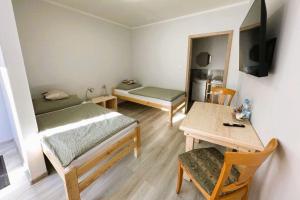 mały pokój z 2 łóżkami i stołem w obiekcie Olszyna Pod Brzozą w mieście Olszyna