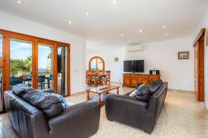 聖佩德羅科羅尼亞的住宿－Ca n' Auba，客厅配有两张真皮沙发和一台电视机
