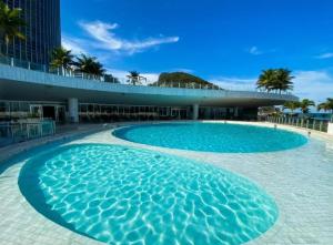 uma grande piscina azul em frente a um edifício em Hotel Nacional Rio de Janeiro Reveillon no Rio de Janeiro