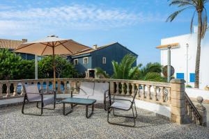 a patio with a table and chairs and an umbrella at Ca n' Auba in Colonia de Sant Pere