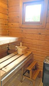 Cette chambre en bois dispose d'un seau sur un banc et d'une fenêtre. dans l'établissement Cozy house on Parnassos Mountain, à Arachova