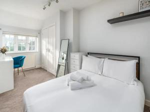 1 dormitorio con 1 cama blanca grande con silla azul en Pass the Keys Stylish Modern 3 bed house with Parking, en Rickmansworth
