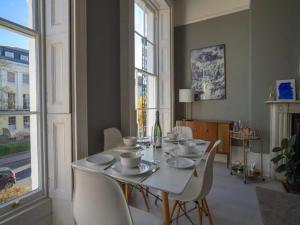 comedor con mesa blanca y sillas en Pass the Keys Lovely bright and central apartment in Cheltenham en Cheltenham