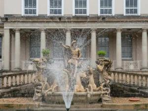 a fountain with statues in front of a building at Pass the Keys Lovely bright and central apartment in Cheltenham in Cheltenham