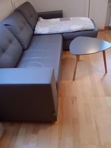 a blue couch and a stool in a living room at Hexenstube-Dorolina in Hohegeiß +2 photos