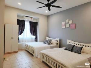 een slaapkamer met 2 bedden en een plafondventilator bij Tmn seri botani ipoh greece 4br 14pax mahjong in Ipoh