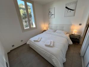 een slaapkamer met een groot wit bed en 2 handdoeken bij My Residence d'Azur Maison Micheloni in Beausoleil
