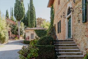 een stenen huis met een trap naar een gebouw bij Fattoria del Colle in Trequanda