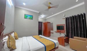 a hotel room with a bed and a tv at FabHotel Gateway Suites in Bangalore