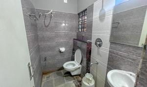 a bathroom with a toilet and a sink at FabHotel Gateway Suites in Bangalore