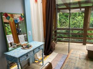 Pokój z niebieskim stołem i lustrem w obiekcie Shanti Yoga Forest House w mieście Florianópolis
