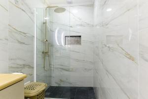 a bathroom with a shower with white marble walls at Casa do Sol in Funchal