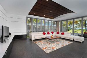 a living room with white furniture and red pillows at Deluxe Beach Villas by Danatrip in Danang