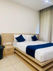 um quarto com uma cama grande e almofadas azuis em Mount view by farstay em Wayanad