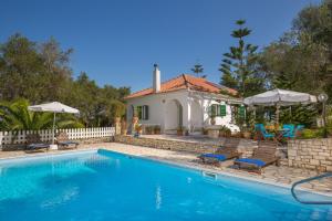 a swimming pool with chairs and a house at Villa Maria in Kagkátika