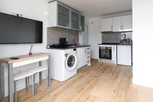 a kitchen with a washing machine and a tv on a wall at Casa do Mar in Funchal