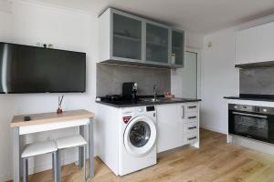 een keuken met een wasmachine en een wastafel bij Casa do Mar in Funchal