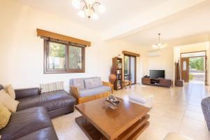 ein Wohnzimmer mit einem Sofa und einem Tisch in der Unterkunft Villa Kambos Ena in Polis Chrysochous