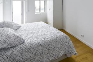 um quarto com uma cama com um cobertor xadrez em Casa do Mar em Funchal