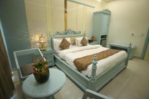ein Schlafzimmer mit einem Bett und einem Tisch mit einer Blumenvase in der Unterkunft Hotel Sita International in Neu-Delhi