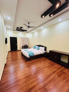 a bedroom with a bed and a wooden floor at Athirappilly Inn in Athirappilly