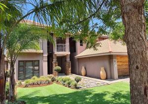 a large house with a green lawn in front of it at 10 Pecanwood Dr 4 Bedroom Beauty in Hartbeespoort