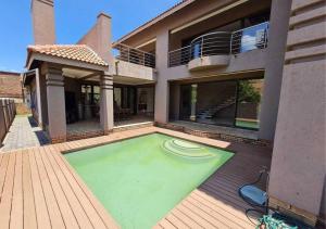 a house with a swimming pool with a frisbee in it at 10 Pecanwood Dr 4 Bedroom Beauty in Hartbeespoort