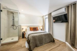 a bedroom with a bed and a shower and a television at Estudio funcional Plaza del Callao in Madrid