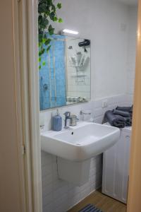 La salle de bains blanche est pourvue d'un lavabo et d'un miroir. dans l'établissement La grotta bianca, à Naples