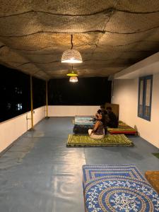 Eine Frau, die auf dem Boden eines Raumes mit Matten sitzt. in der Unterkunft The Barefoot Varkala in Varkala